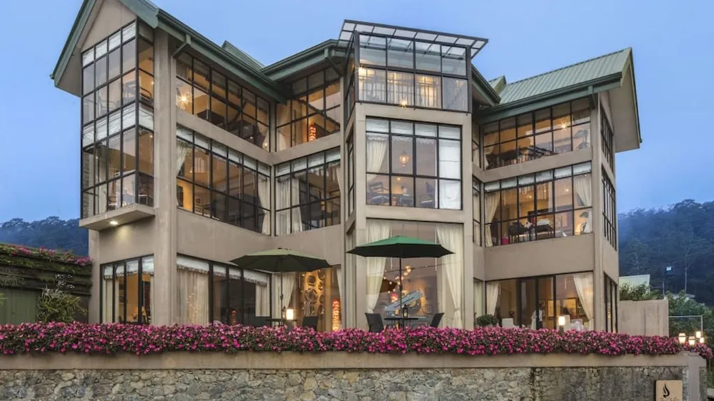 The Cheriz, a glass-fronted hillside property in the evening